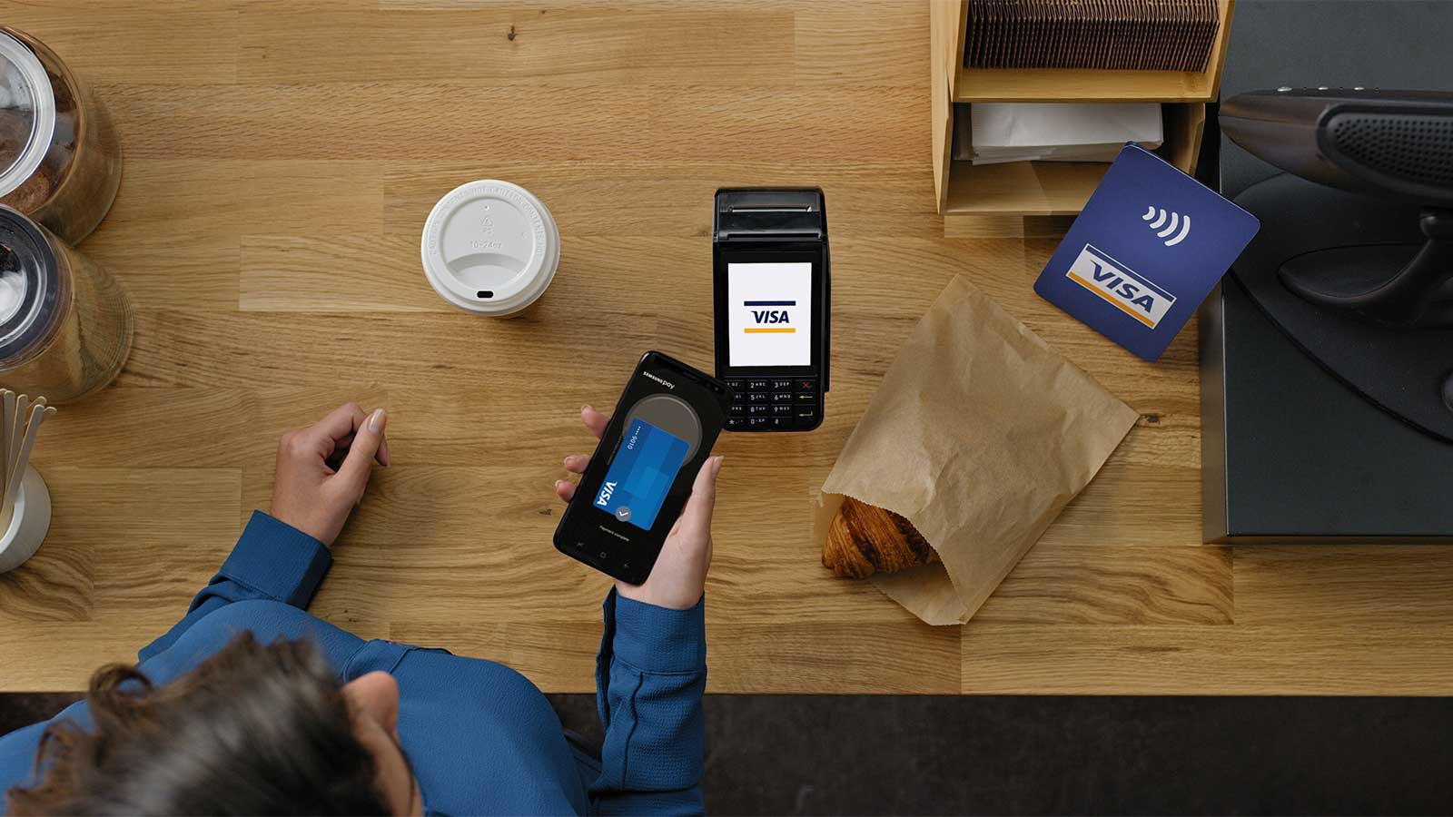 Customer paying for a purchase via a mobile phone using Samsung Pay.