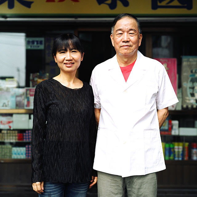 asian couple standing infront of a storefront